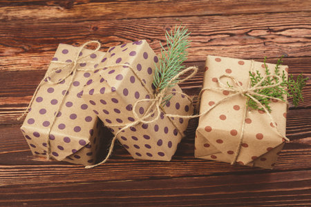 Stylish decorated christmas gifts over brown wooden background