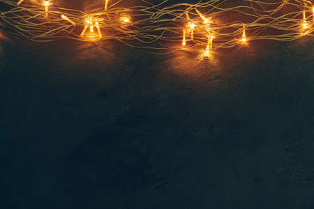 Warm light illuminated garland close up on dark backgroundの写真素材