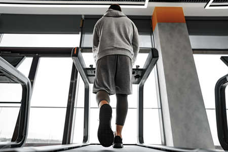 Close up of male legs running in a gym on a treadmill