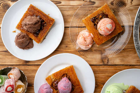 Turkish dessert kunefe served with ice cream on wooden background