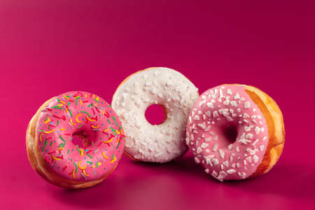Yummy glazed round donut on a bright pink backgroundの写真素材