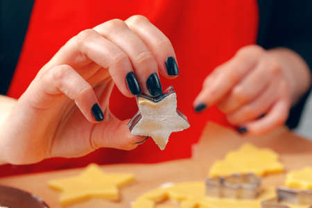 female hands making cookies from fresh dough at homeの写真素材
