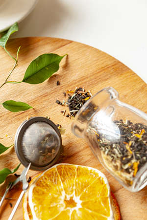 Cup of hot black tea on white table with dry tea jarの写真素材