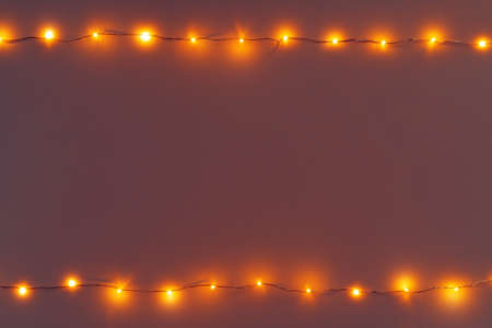 Glowing golden electric garland on a gray backgroundの写真素材