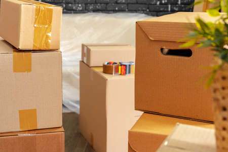 Moving in or moving out concept. Stack of boxes and packed furniture