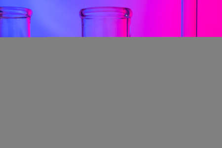 Chemical glassware close up on neon pink-purple backgroundの写真素材
