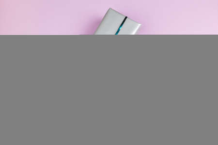 Top view of a decorated present with a bow on pink backgroundの写真素材