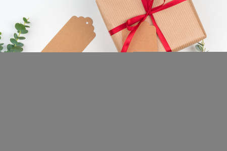 Gift boxes packed in craft paper with simple decor of green plant branchesの写真素材