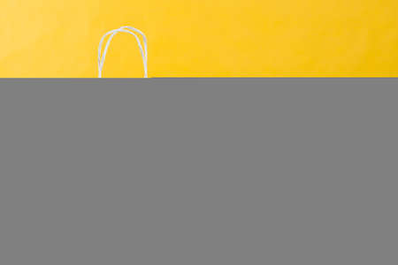 Arrangement of shopping bags on bright yellow backgroundの写真素材