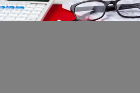 Red office desk table with blank notebook, keyboard and supplies. Top view with copy space. Flat lay.の写真素材