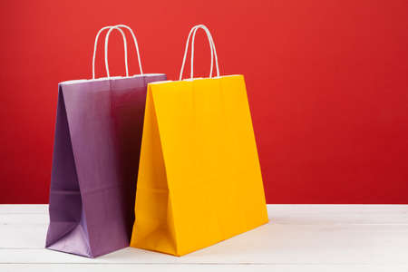 Paper shopping bags with copy space on red backgroundの写真素材