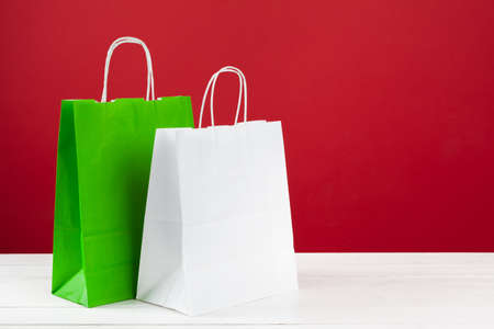 Several shopping bags with copy space on red backgroundの写真素材
