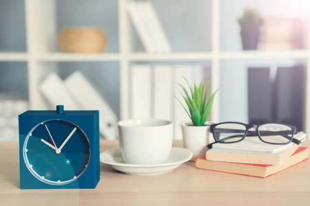 Classic vintage alarm clock and coffee cup on wooden backgroundの写真素材