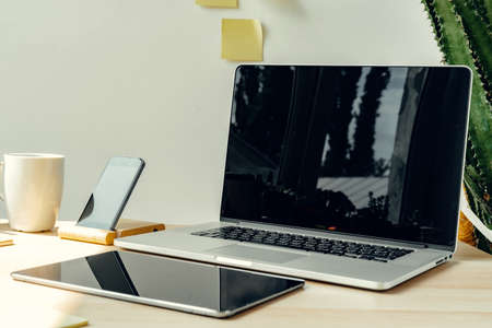 Laptop in a light room on working table with office suppliesの写真素材