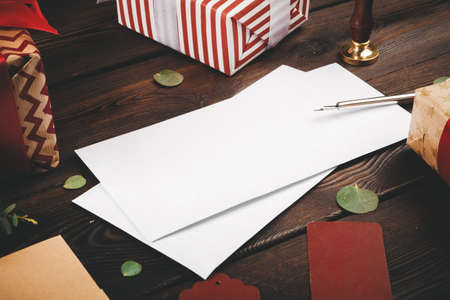 Empty letter with a feather on old wooden background decorated with Christmas objectsの写真素材