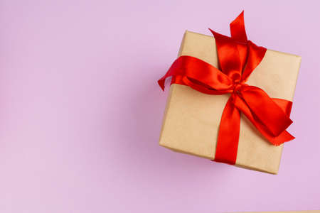 Top view of a decorated present with a bow on pink backgroundの写真素材