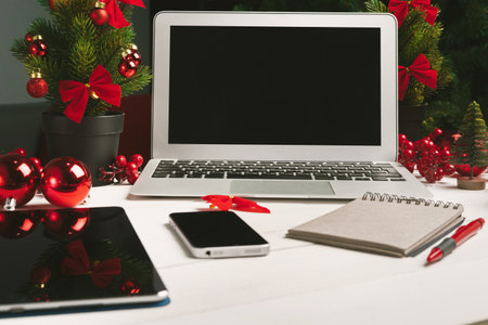 Open notepad and computer on table with christmas decorの写真素材