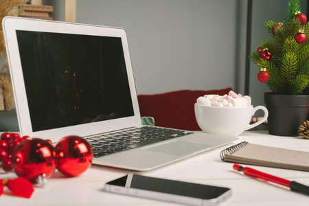 Open notepad and computer on table with christmas decorの写真素材