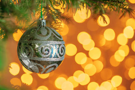 Christmas tree background with grey bauble on golden bokeh sparklingの写真素材