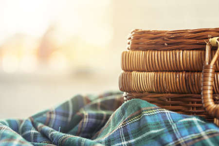 Close up of a wooden basket with dishware on white tableの写真素材
