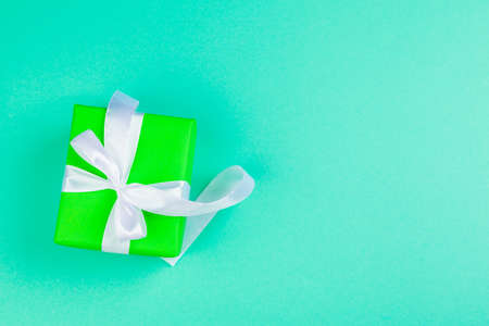 Decorated gift box on a green background, flat lay top viewの写真素材