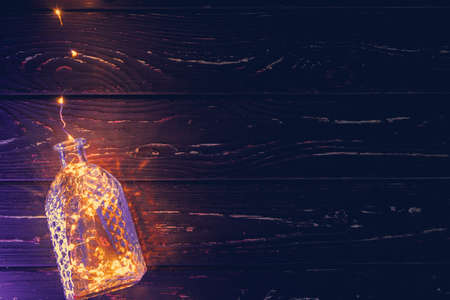 Lights garland in a glass bottle on a dark backgroundの写真素材