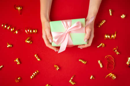 Woman hands holding gift box top viewの写真素材