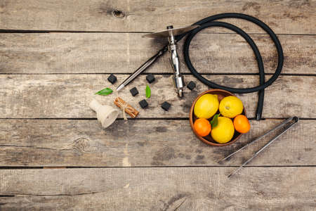 Parts of hookah and fruits on wooden backgroundの写真素材
