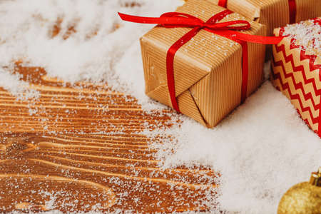 Craft gift boxes over snowy wooden table close upの写真素材