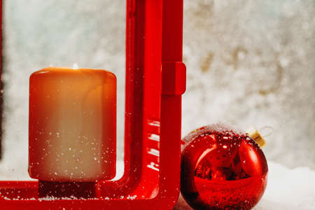 Christmas red lantern with burning candle on wooden tableの写真素材