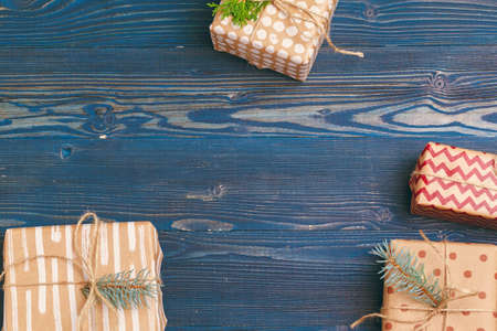 Christmas gifts with fir tree branches on wooden background