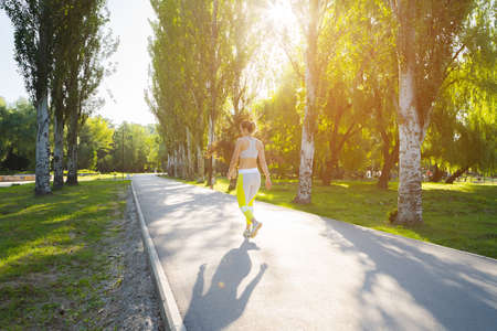Sporty young woman in sportswear running in the park in the morningの写真素材