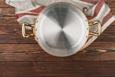 Copper pot with chekered tablecloth on wooden tableの写真素材