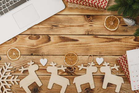 Wooden table with office equipment and stationery surrounded with new year festive decor, view from aboveの写真素材