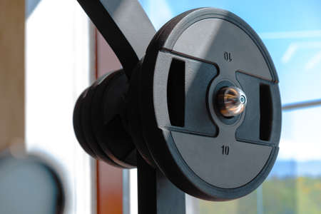 Weight plate on metal barbell in a gym
