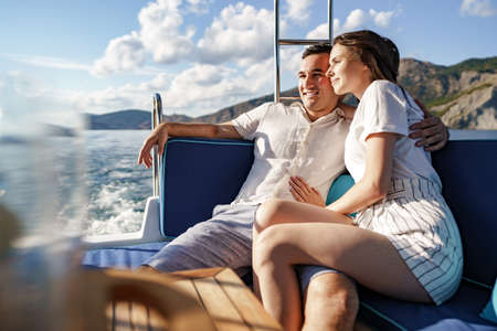 Happy couple on a yacht in summer on romantic vacationの写真素材