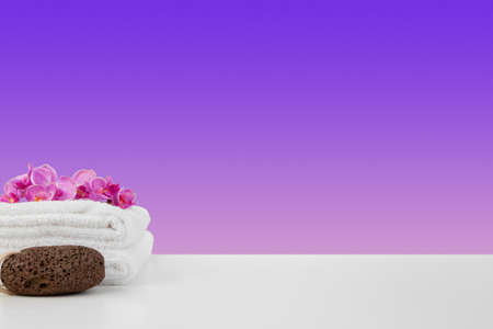 Beautiful pink flowers and white towels on pink backgroundの写真素材