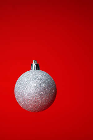 Levitating in air christmas bauble over red background. Christmas cardの写真素材