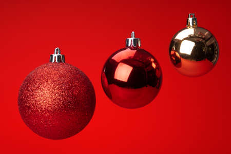Levitating in air christmas bauble over red background. Christmas card