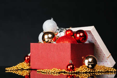 Cardboard box full of christmas decorations on a dark black background