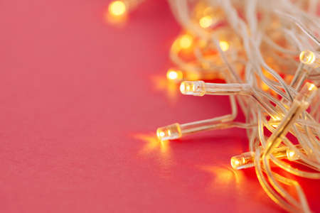 Illuminated garland lights on bright pink background