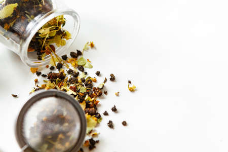 Glass jars with dry tea leaves close up on white tableの写真素材