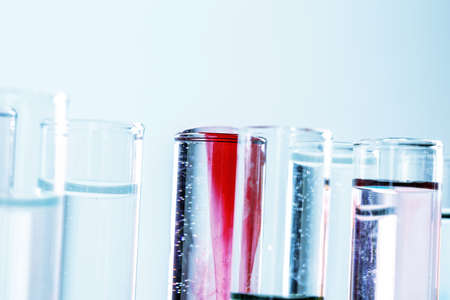Different laboratory glassware with colored liquids close up