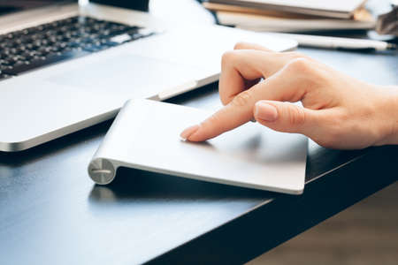 Close up of woman hand touching on laptop computer mouse padの写真素材