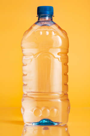 Plastic bottle of mineral water on a bright yellow backgroundの写真素材