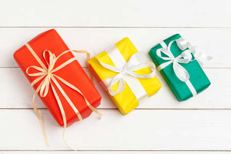 Wrapped gifts with ribbon on white wooden background top viewの写真素材