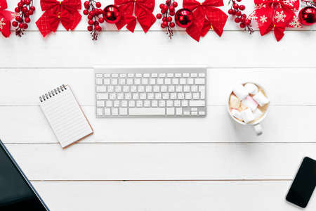 Office table with devices, supplies and christmas decor. View from aboveの写真素材