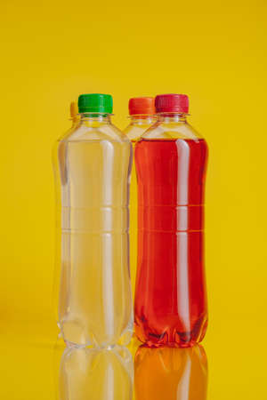 Plastic bottle full of drink on a bright yellow backgroundの写真素材