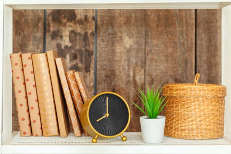 Stylish white bookshelf against grunge wooden wallの写真素材