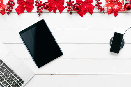 Office table with devices, supplies and christmas decor. View from aboveの写真素材